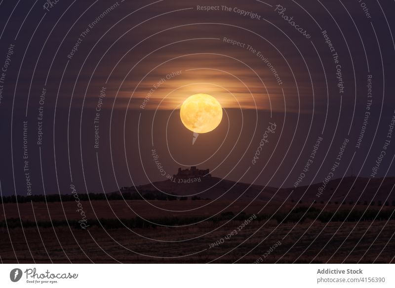 Der Mond leuchtet über einer fernen Burg und einem Feld Landschaft Himmel Burg oder Schloss Hügel dunkel Glanz entfernt Natur Abend Dämmerung Abenddämmerung