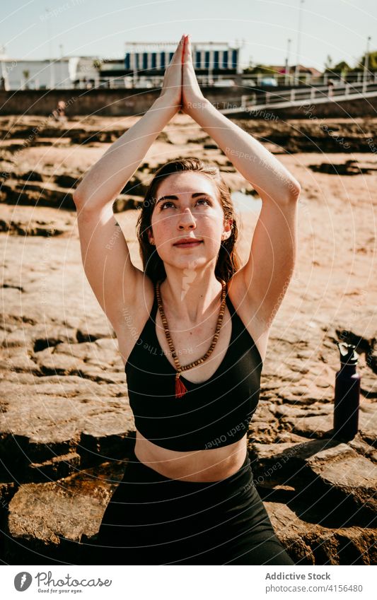 Frau übt Yoga am felsigen Strand Namaste Pose üben Asana Sommer beten gestikulieren Windstille Harmonie friedlich Wellness Gelassenheit Konzentration Zen Natur