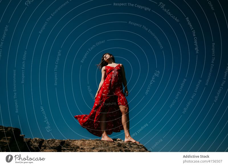 Anmutige Frau im Kleid auf felsigem Hügel rot Angebot Freude sich[Akk] bewegen schlank Barfuß Felsen Blauer Himmel wolkenlos Himmel (Jenseits) Natur