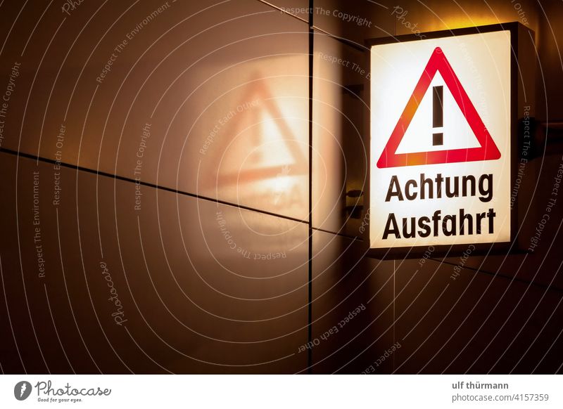 Achtung Ausfahrt Hinweisschild Verkehrsschild nachts beleuchtet Warnschild Zeichen Sicherheit Außenaufnahme Warnhinweis Vorsicht Gefahr Schutz