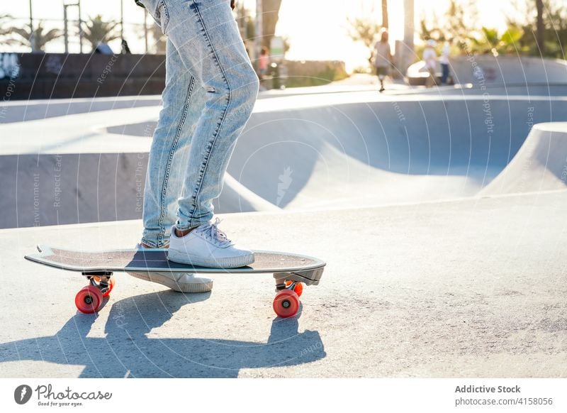 Crop-Skater auf modernem Skateboard im Skatepark Turnschuh Großstadt Schlittschuh Straße Sommer Stil Youngster cool Jeanshose urban Zeitgenosse aktiv Aktivität