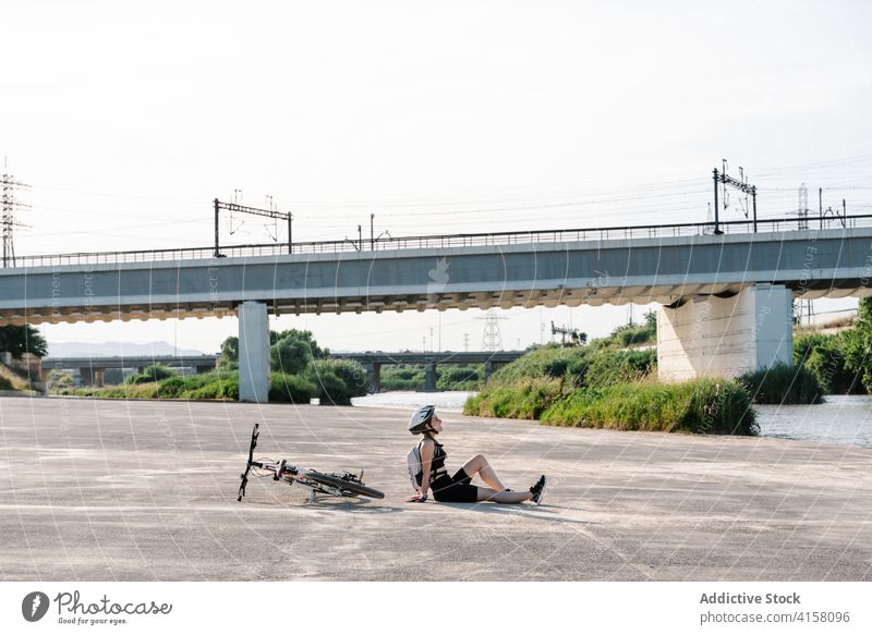 Positive Radfahrerin, die sich auf der Straße ausruht Frau Fahrrad heiter ruhen Aktivität Glück sportlich jung sich[Akk] entspannen Schutzhelm Lifestyle Sport