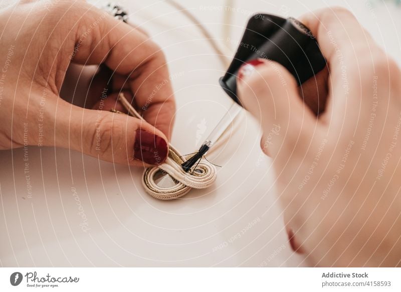 Crop-Frau bei der Herstellung von Soutache-Dekorationen im Atelier Bijouterie Handwerkerin kreieren Kunstgewerbler handgefertigt Handwerkskunst Leim Faser