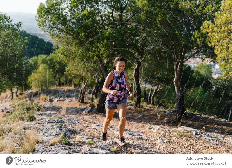 Aktive Frau läuft auf Pfad im Wald Nachlauf laufen Berge u. Gebirge aktiv Training Sport Athlet positiv jung Natur Fitness Lifestyle Sportkleidung