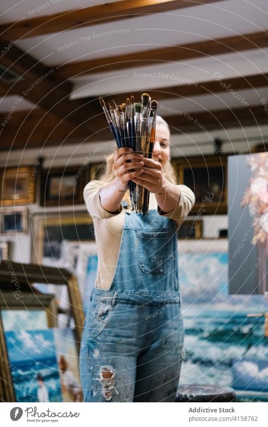 Glückliche Künstlerin mit Pinseln Frau Farbe Pinselblume Bürste kreativ Werkstatt Kunst Talent Werkzeug zeichnen Arbeit Hobby Handwerk Inspiration Kunstwerk