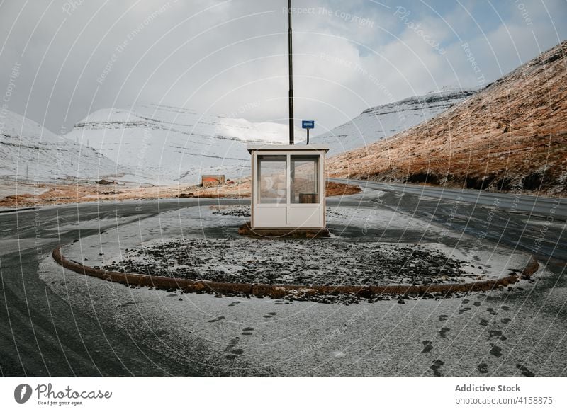 Straße in den Bergen auf den Färöer Inseln Asphalt Berge u. Gebirge Schnee Landschaft leer Natur Winter kalt Fahrbahn wolkig Hügel Ausflug Wetter Saison Weg