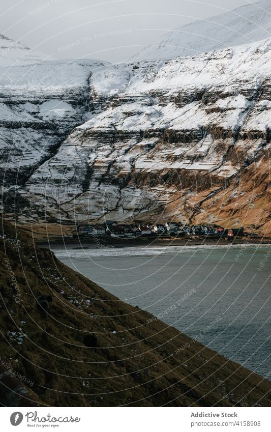 Kleine Siedlung in den Bergen auf den Färöer Inseln Berge u. Gebirge Dorf Wohnsiedlung Winter Schnee Fluss Saison kalt Haus wohnbedingt Färöer-Inseln Landschaft