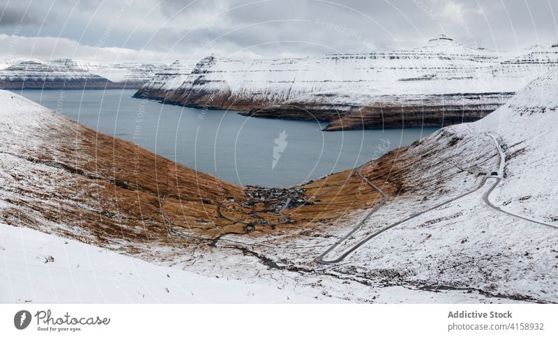 Kleine Siedlung in den Bergen auf den Färöer Inseln Berge u. Gebirge Dorf Wohnsiedlung Winter Schnee Fluss Saison kalt Haus wohnbedingt Färöer-Inseln Landschaft