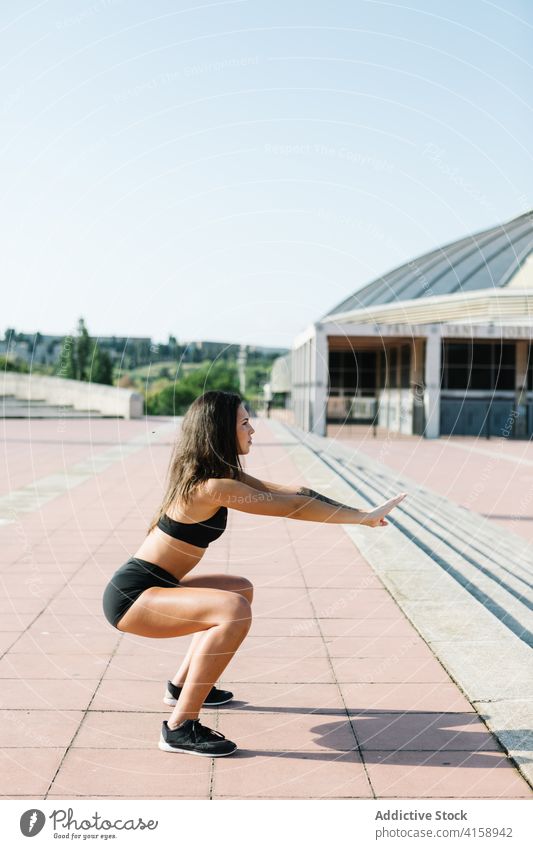 Entschlossene Sportlerin beim Squad-Training auf der Straße Frau Übung Bestimmen Sie Ausdauer Athlet Kerngehäuse intensiv Muskel passen jung Truppe schlank