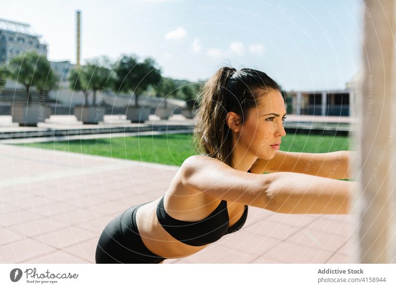 Sportliche Frau macht Dehnungsübungen in der Nähe der Wand Training Übung Wade Straße urban Athlet passen Sportlerin Läufer Jogger Muskel jung schlank Fitness