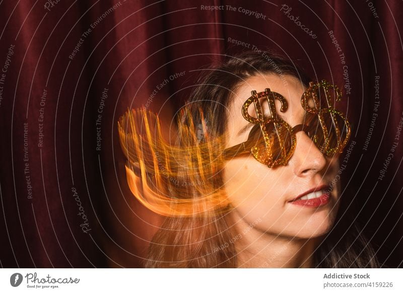 Unbekümmerte Frau mit Partybrille und Kleid Sonnenbrille Glamour golden feiern Spaß haben Feiertag dunkel schimmern ausgefallen Brille schwarz Inhalt trendy