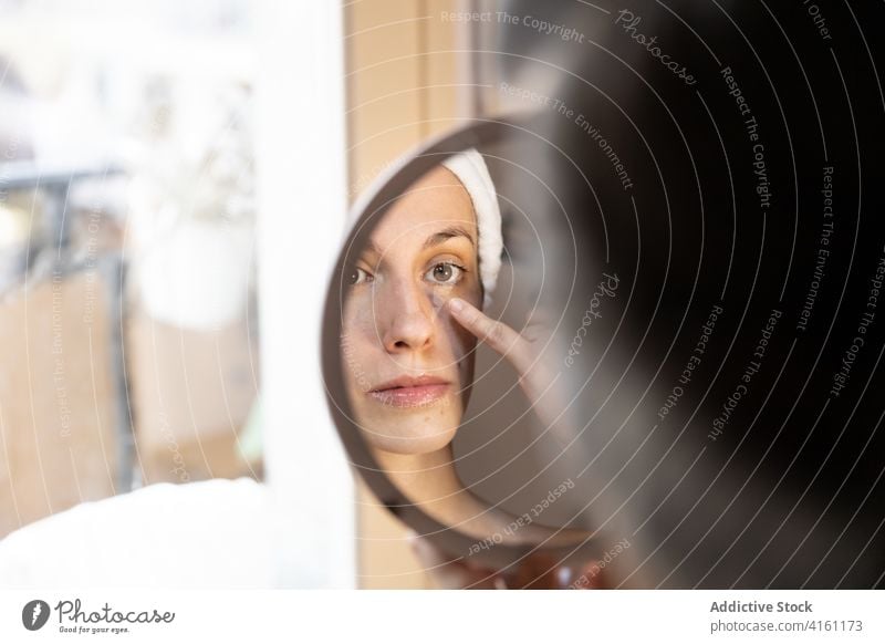 Junge Frau trägt Lidschatten mit der Hand auf bewerben Reflexion & Spiegelung Fenster Make-up jung Überarbeitung Stirnband Kosmetik Lifestyle Routine natürlich