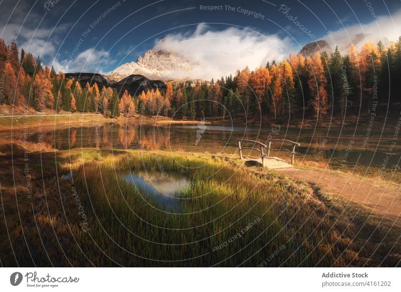 Kleine Brücke in der Nähe des Sees reflektiert hellen Herbst Bäume Baum Reflexion & Spiegelung Berge u. Gebirge Natur wolkig Blauer Himmel Atmosphäre fallen