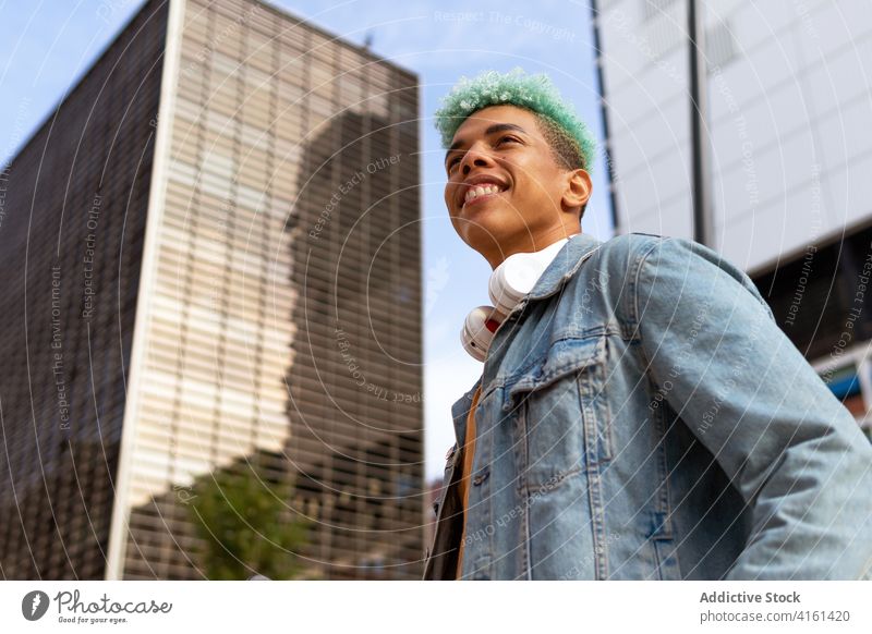 Begeisterter trendiger schwarzer Mann in der Stadt Hipster blaue Haare gefärbtes Haar Großstadt trendy Straße heiter Vorschein Frisur männlich ethnisch