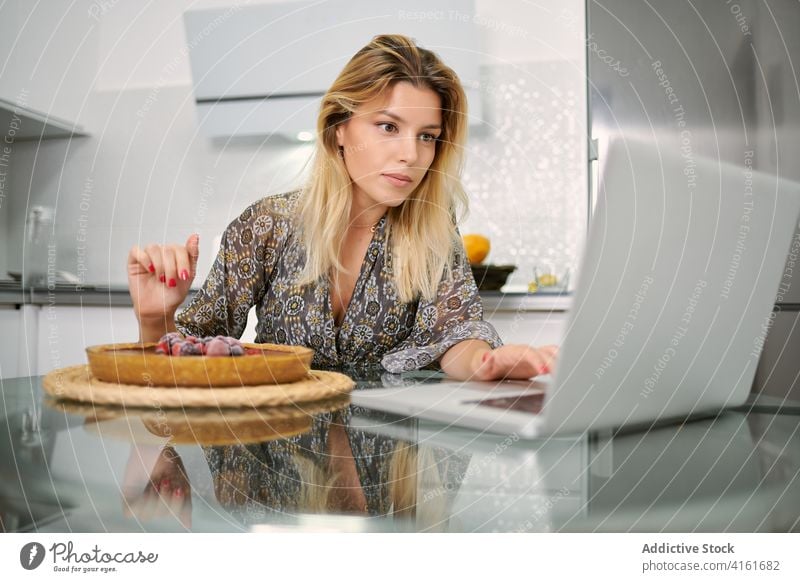 Junge Frau, die zu Hause eine Torte mit Beeren zubereitet Dessert vorbereiten Kuchen gesunde Ernährung Veganer Garnierung dekorieren Gebäck Lebensmittel Küche