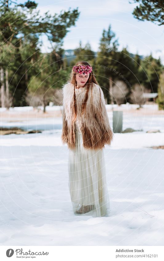 Nordische Braut in Pelzmantel auf verschneiter Wiese stehend Frau Mode nordisch Hochzeit Fell Schnee Stil Natur Wald Totenkranz Saison blond Winter Frühling