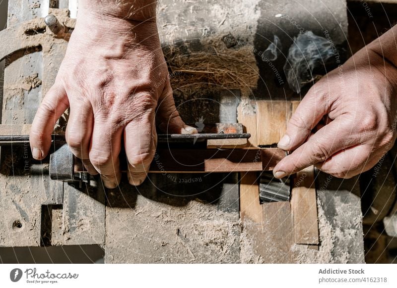 Männlicher Schreiner bei der Arbeit mit Holz in der Garage Tischlerin Werkstatt Mann Holzarbeiten Zimmerer Schreinerei Detailaufnahme alt Hobelbank Industrie