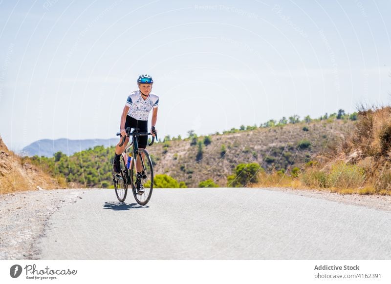 Radfahrer auf der Landstraße im Hochland Fahrrad Mitfahrgelegenheit Straße Berge u. Gebirge aktiv Sport Route Training Natur Frau Lifestyle Aktivität Gesundheit