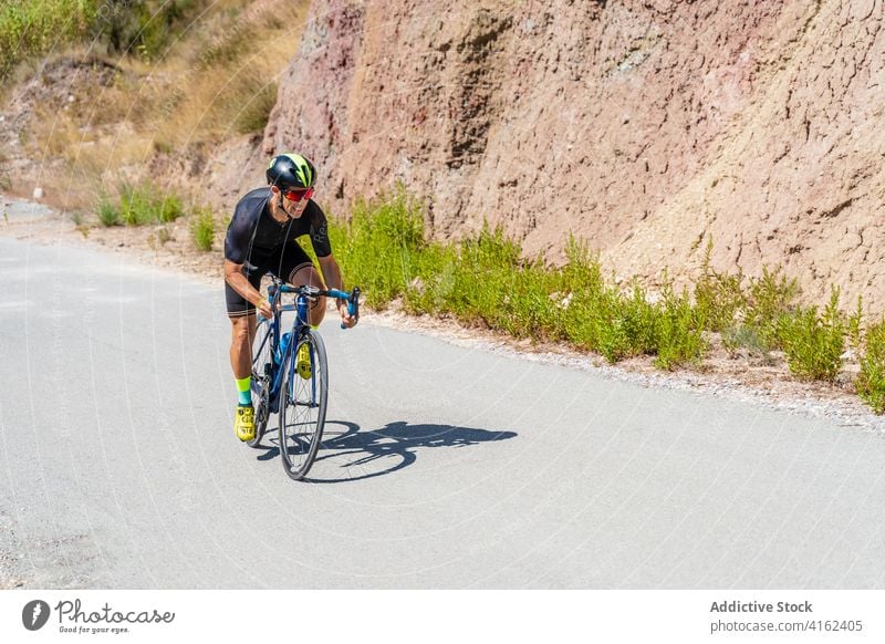 Sportlicher Radfahrer fährt Fahrrad auf Bergstraße Mitfahrgelegenheit Berge u. Gebirge Straße Training aktiv Lifestyle Ausdauer Aktivität Gesundheit Sommer