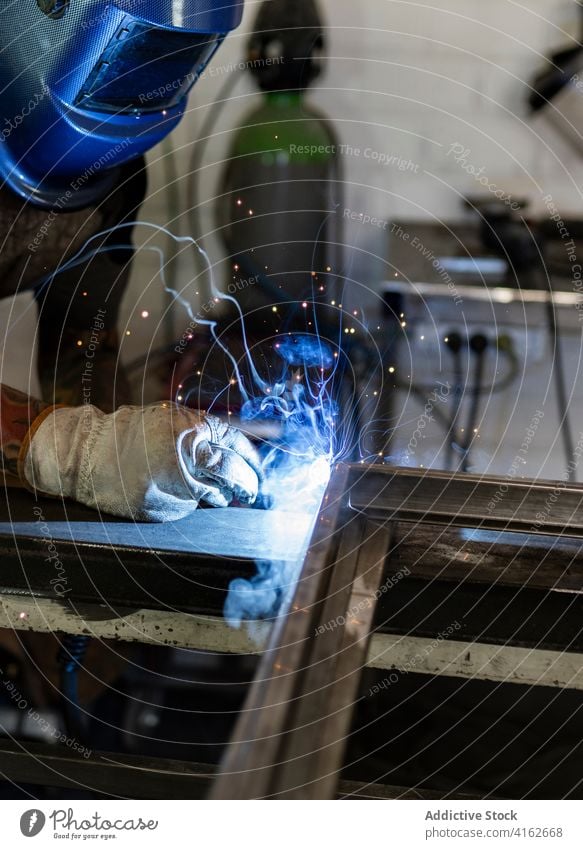 Fabrik männlicher Arbeiter, der Metallkonstruktionen herstellt Schweißnaht Maschine Schweißer Mann Metallbearbeitung Prozess Funken Hobelbank Gerät Industrie