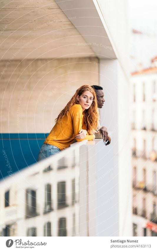 Afrikanischer Junge und rothaarige Frau in die Kamera schauen Stehen Vorderansicht Porträt Partnerschaft multirassisch Schwarzer Mann Kaukasier multikulturell