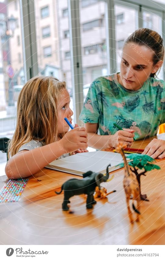 Mutter erklärt ihrer Tochter die Hausaufgaben Lehre zu erklären. konzentriert verstehen Bildung Versöhnung Familienarbeit qualitätsvolle Zeit lernen