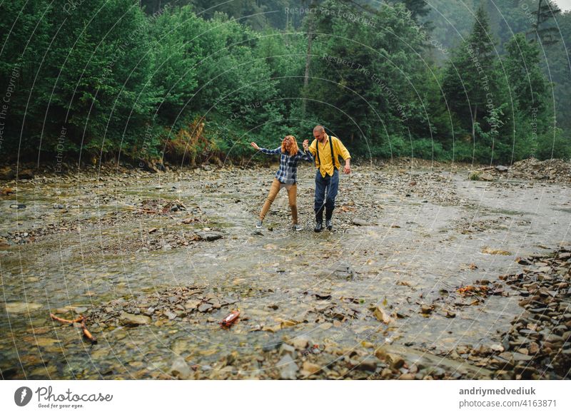 Playful glücklich gut aussehend Paar beim Spaziergang im Wald haben. Abenteuer in der Natur Konzept. Paar in den Bergen Glück aktiv Partnerschaft Wälder Liebe