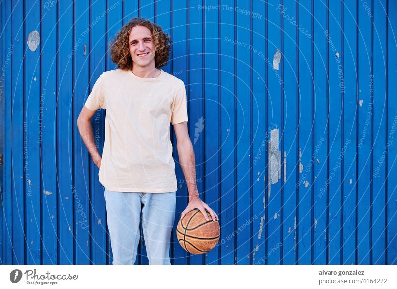 junger Mann mit lockigem Haar mit seinem Basketball in der Hand che Ball Person Korb Sport sportlich männlich Spiel Spieler wettbewerbsfähig Hintergrund