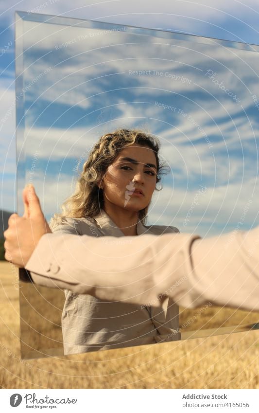 Modisches weibliches Modell, das sich im Spiegel auf einer Wiese spiegelt Frau Reflexion & Spiegelung Anmut Stil Glamour Gelassenheit traumhaft sinnlich