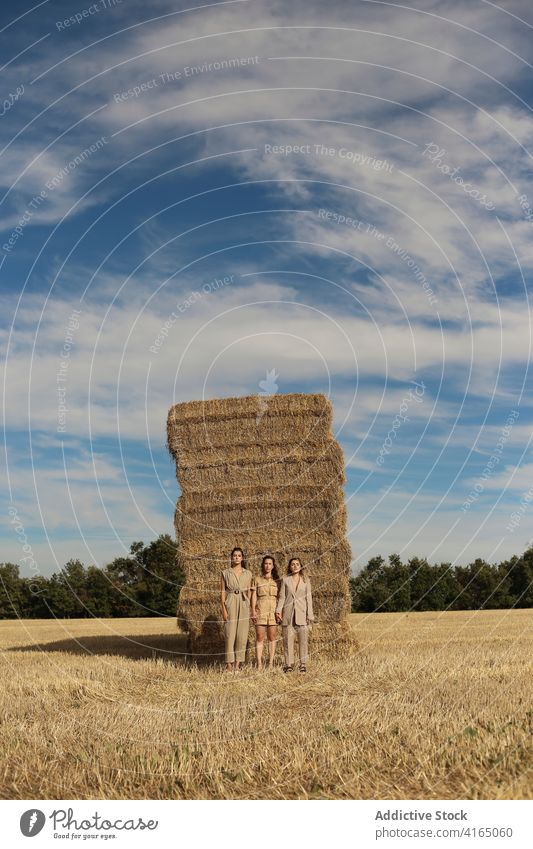 Stilvolle Freundinnen stehen auf trockenem Heu im Feld Frauen Heugarben Landschaft Model Zusammensein Zeit verbringen trendy sich[Akk] entspannen Gelassenheit