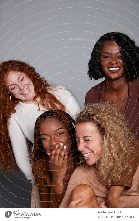 Gruppe von verschiedenen Frauen, die Spaß im Studio haben Lachen Freundschaft sich[Akk] sammeln Witz Spaß haben Atelier krause Haare Geflecht heiter