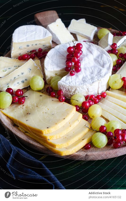 Leckere Käseplatte mit Weintrauben und Johannisbeeren Platte sortiert Parmesan Mozzarella Scheibe Camembert geschmackvoll lecker verschiedene Speise appetitlich