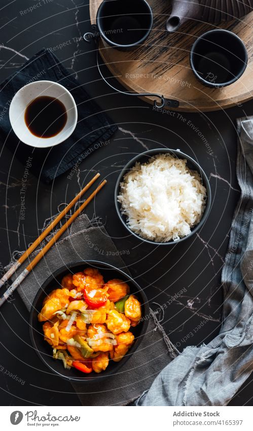 Appetitliche asiatische Gerichte, serviert auf dem Tisch mit Sojasauce und Teeservice Reis Hähnchen Speise Asiatische Küche Essstäbchen lecker appetitlich