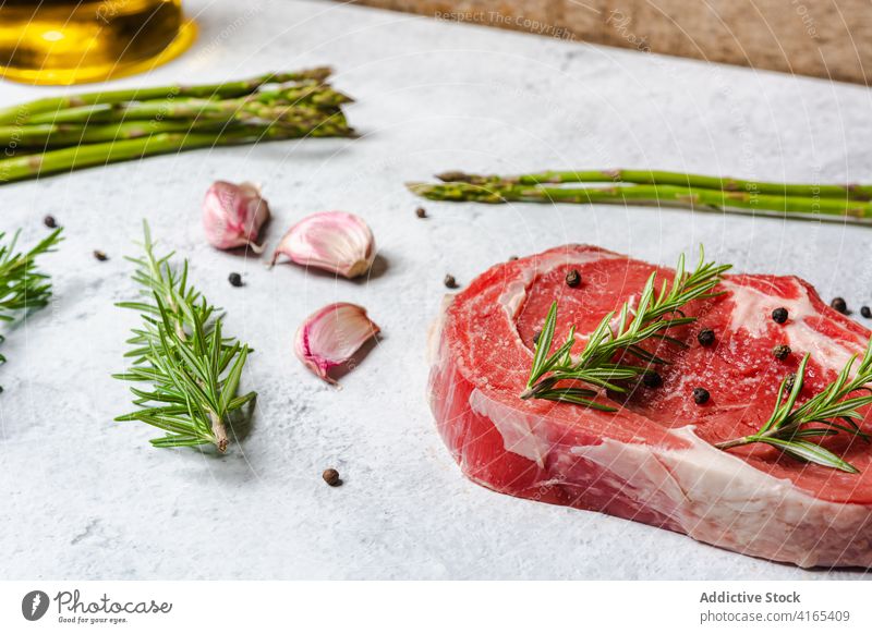 Rohes Rindersteak mit Kräutern auf dem Tisch Rindfleisch Steak roh Knochen t Knochen Rosmarin Garnierung Fleisch Paprika schwarz Küche Koch Lebensmittel lecker