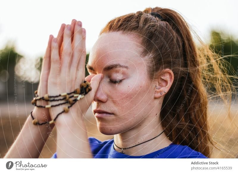 Frau meditiert mit geschlossenen Augen beim Yoga meditieren Natur ruhig Zen Namaste Harmonie Sonnenuntergang friedlich Windstille Asana üben idyllisch