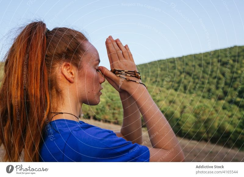 Frau meditiert mit geschlossenen Augen beim Yoga meditieren Natur ruhig Zen Namaste Harmonie Sonnenuntergang friedlich Windstille Asana üben idyllisch