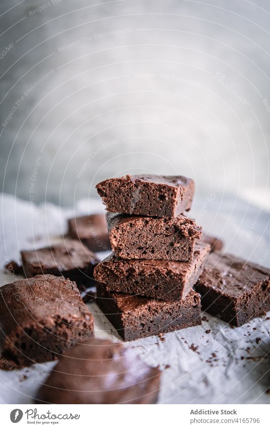 Leckere Schokoladen-Brownie-Scheiben auf Pergament zu Hause Pasteten Spielfigur Dessert Leckerbissen süß lecker Haufen heimwärts Wand glänzend selbstgemacht