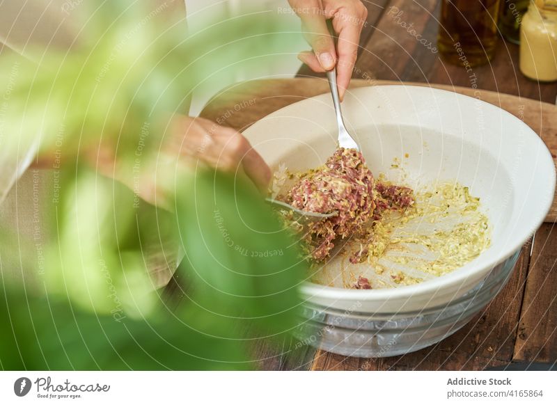 Anonymer Koch kocht Steak Tartar mischen Bestandteil Frau Küchenchef professionell Speise roh Rindfleisch Fleisch Senf lecker vorbereiten Lebensmittel frisch