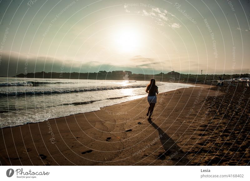 Warmer Sonnenuntergang am Meer Westen Sandstrand Fußabdrücke im Sand warme Jahreszeit Abendhimmel Abendsonne glückliche Menschen Urlaub Insel