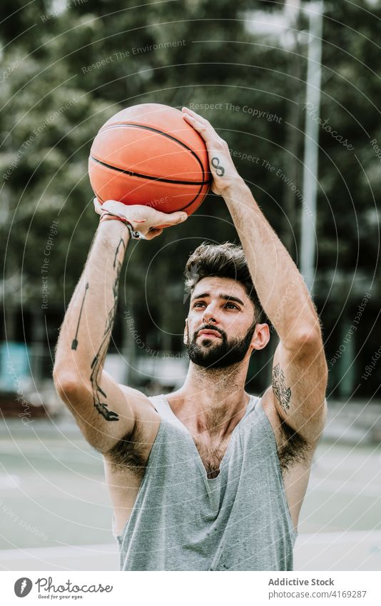 Basketballspieler schießt Ball auf Sportplatz Mann spielen schießen Sprung Reifen werfen Korb Bestimmen Sie springen Spieler Straße Streetball männlich