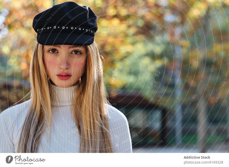 Millennial-Frau mit trendiger Mütze im herbstlichen Park Stil Verschlussdeckel Hut Herbst Mode trendy urban lässig jung blond Outfit Saison Lifestyle Dame