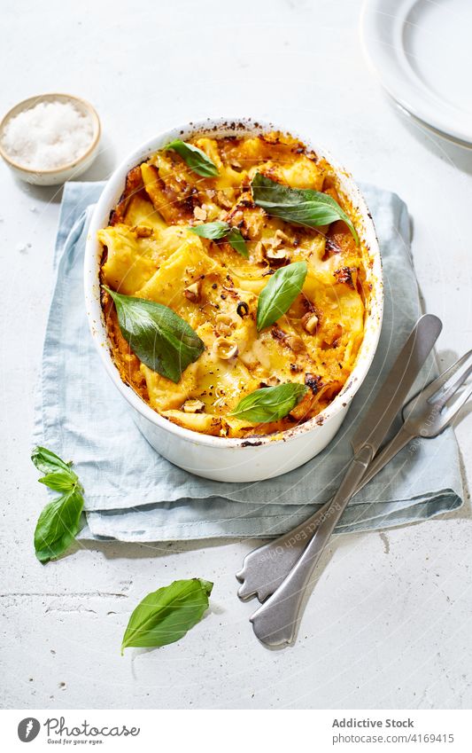 Appetitlicher gebackener Kürbis auf dem Tisch serviert Squash Speise Veganer Vegetarier Lebensmittel Gemüse Garnierung Basilikum lecker grün Abendessen