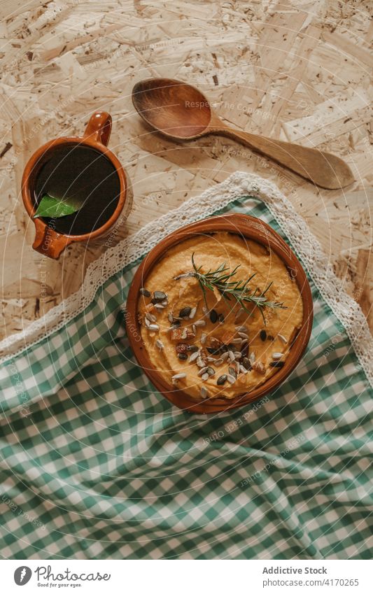 Leckerer hausgemachter Hummus auf dem Tisch Speise selbstgemacht gestampft Kichererbsen dienen Vegetarier Lebensmittel gesunde Ernährung Veganer Tee Tasse