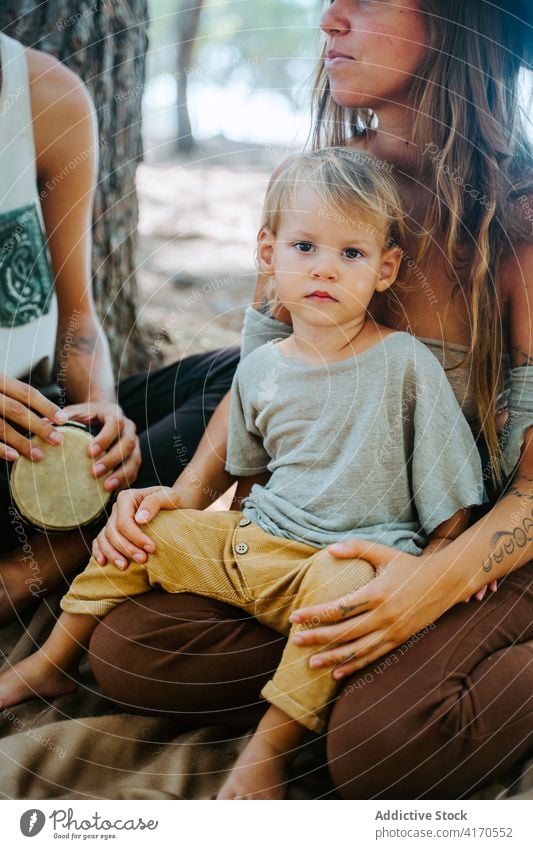 Mutter und Vater mit Kind im Wald Familie Wange Liebe kuscheln Zusammensein Einheit multiethnisch rassenübergreifend vielfältig Umarmung Angebot Tochter Eltern