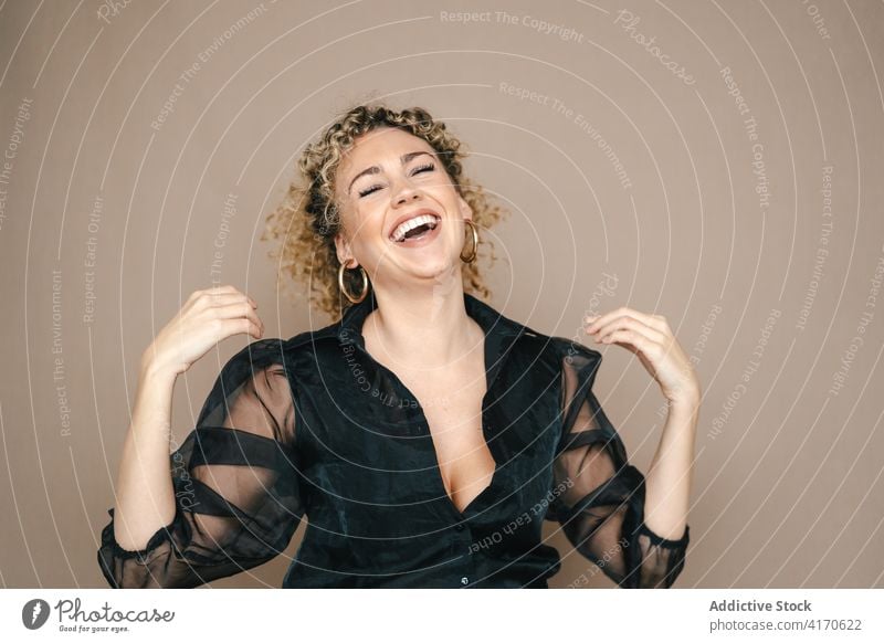 Positive Frau lacht im Studio Lachen Spaß haben offen herzlich positiv Stil Augen geschlossen krause Haare Afro-Look Frisur heiter Glück froh sorgenfrei