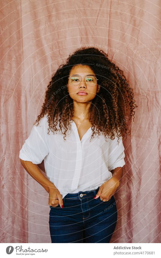 Schwarze Frau schaut in die Kamera Afro-Look Frisur charmant Jugend lässig Stil ethnisch schwarz Afroamerikaner Outfit krause Haare Freude Brille Optimist Mode