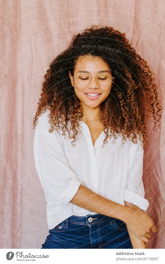 Fröhliche schwarze Frau lächelt mit geschlossenen Augen Augen geschlossen Lächeln heiter Afro-Look Frisur charmant Jugend lässig Stil ethnisch Afroamerikaner