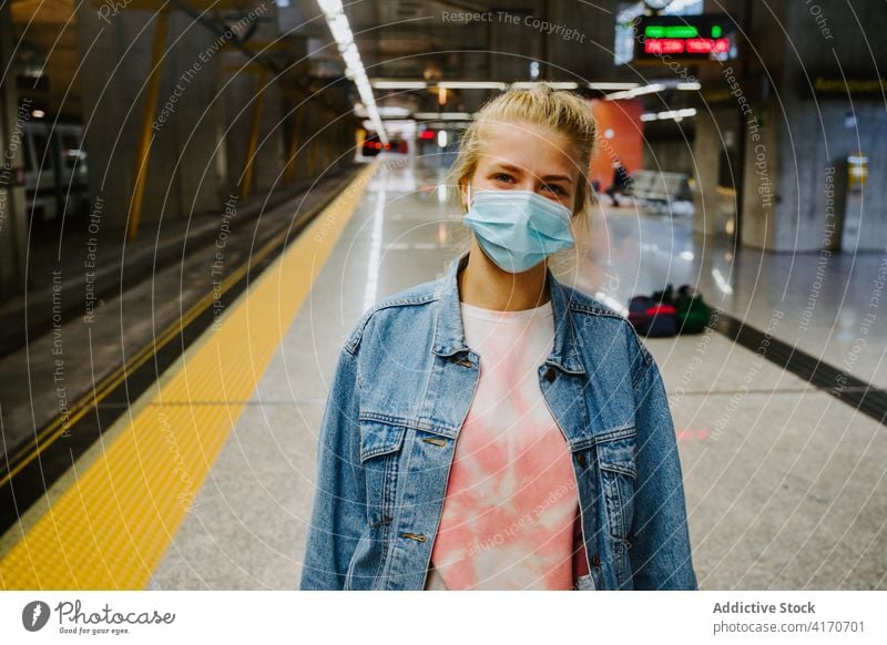 Frau mit Schutzmaske auf dem Bahnsteig eines Bahnhofs Tourist Podest Eisenbahn medizinisch Mundschutz Station Ausflug warten Coronavirus Reise COVID19 Bund 19