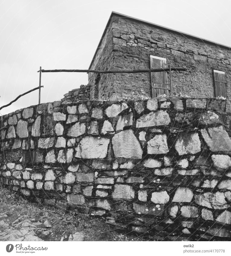 Bollwerk Mauer Steine Mauersteine aufgetürmt hoch fest Geländer Schutz einfach Gebäude Baracke alt verlassen aufgegeben Haus Himmel bedeckt bewölkt Kontrast