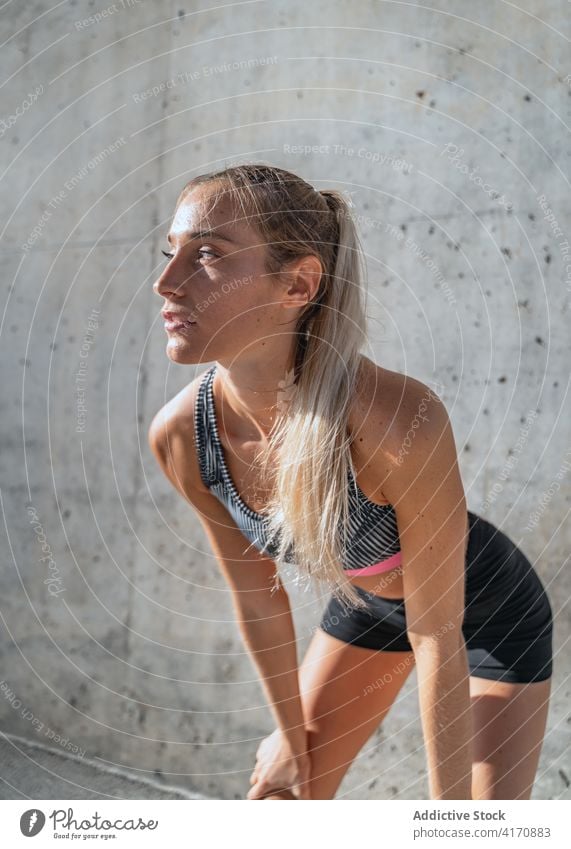 Sportlerin ruht sich in der Stadt aus Pause sich[Akk] entspannen Training Großstadt Frau ruhen modern Gesundheit schlank Wand Athlet Sportbekleidung passen